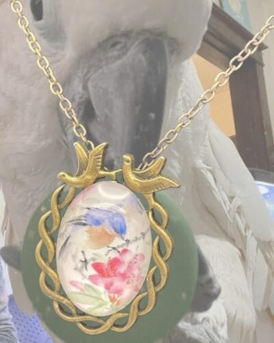 Vintage-inspired bronze bluebird & flower pendant necklace with acrylic cabochon, adjustable 21.65-inch chain.