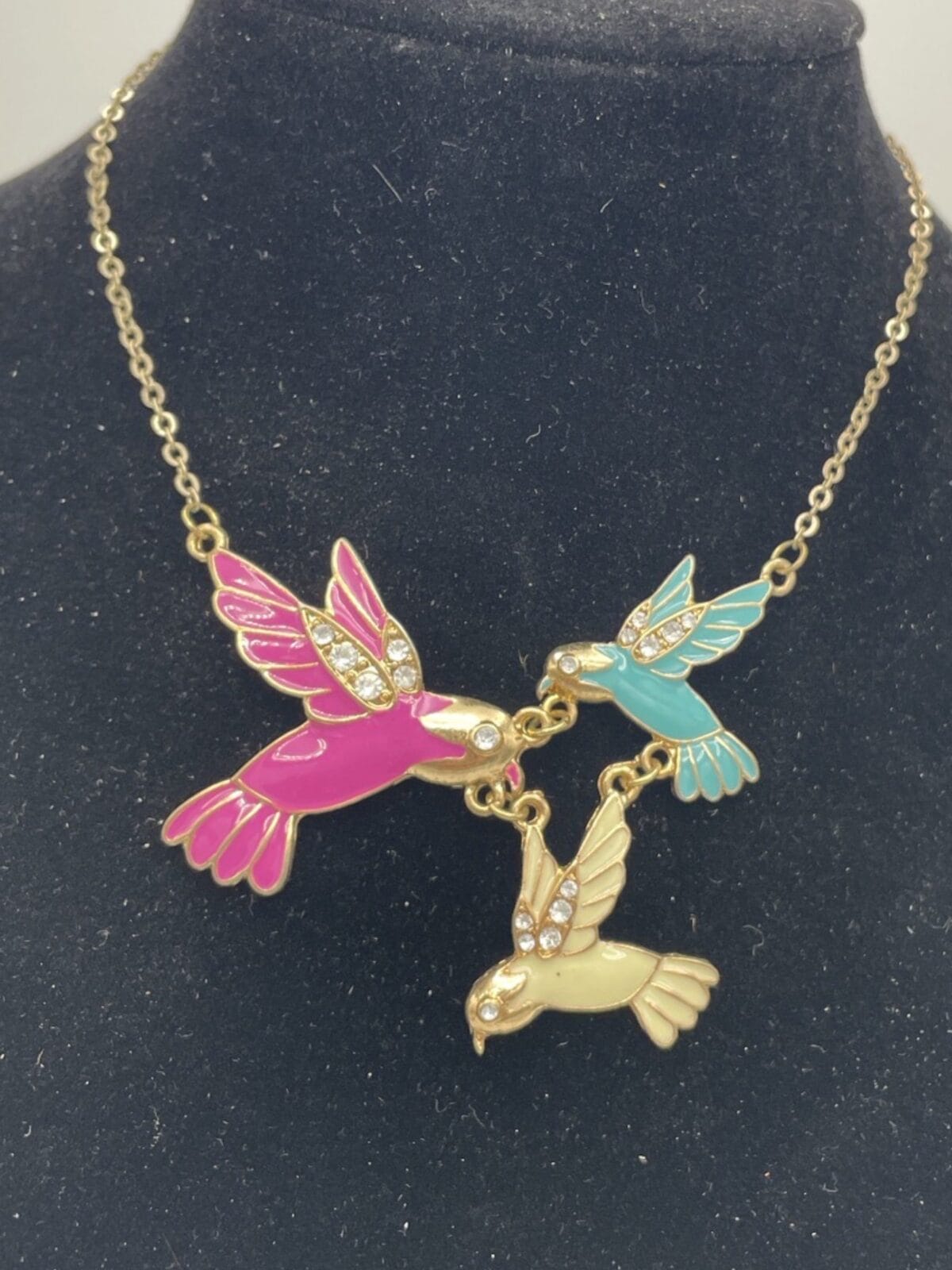 Three Enchanting Enamel Trio of Hummingbirds necklaces on a mannequin.
